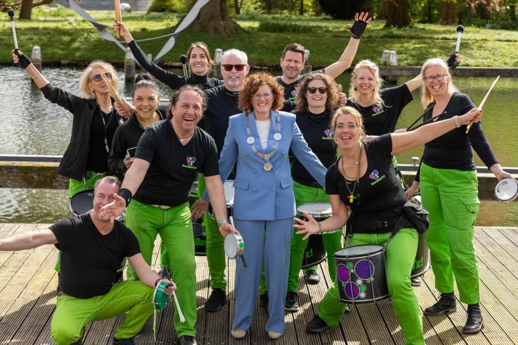 Groepsfoto van de Utrechtse sambaband BooomBassTic en de burgemeester van Nieuwegein tijdens Dag van de Vaart 2024 in Nieuwegein